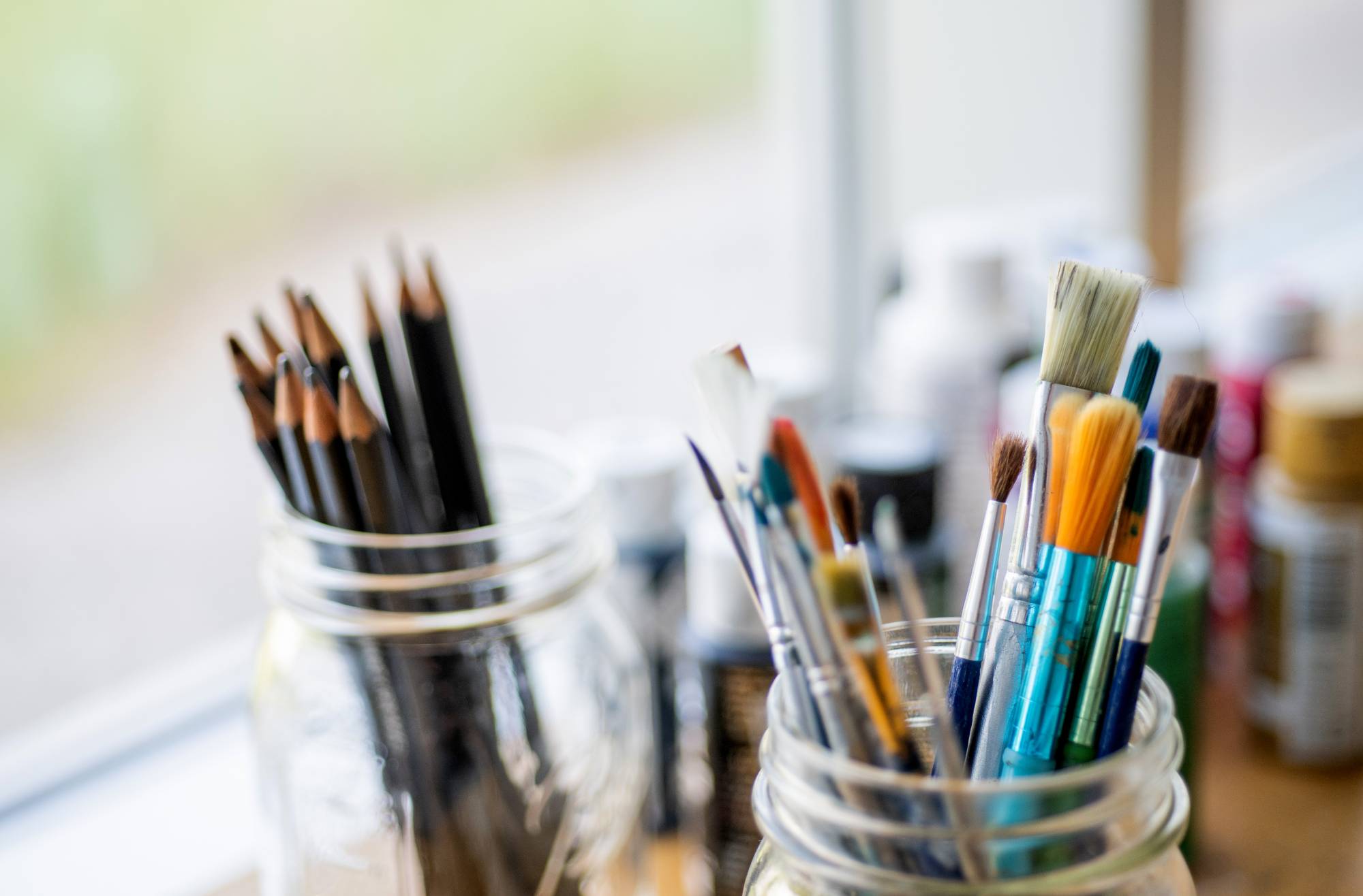 paint brushes and pencils in mason jars